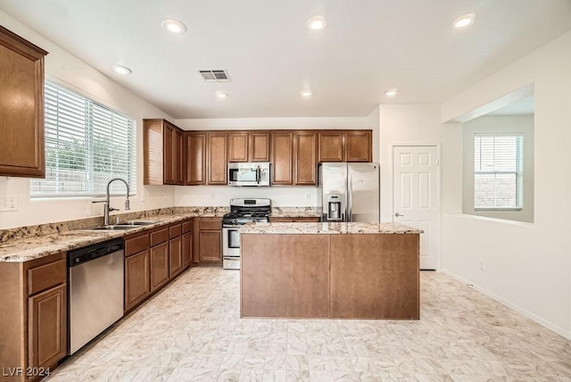 kitchen featuring a center island, a healthy amount of sunlight, sink, and appliances with stainless steel finishes