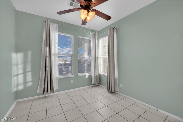 empty room with ceiling fan and light tile patterned floors