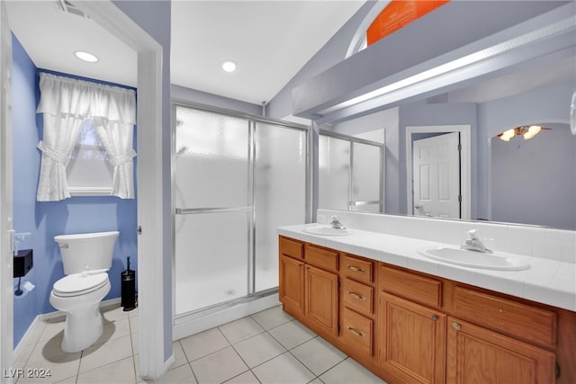 bathroom with toilet, vanity, tile patterned floors, and a shower with door