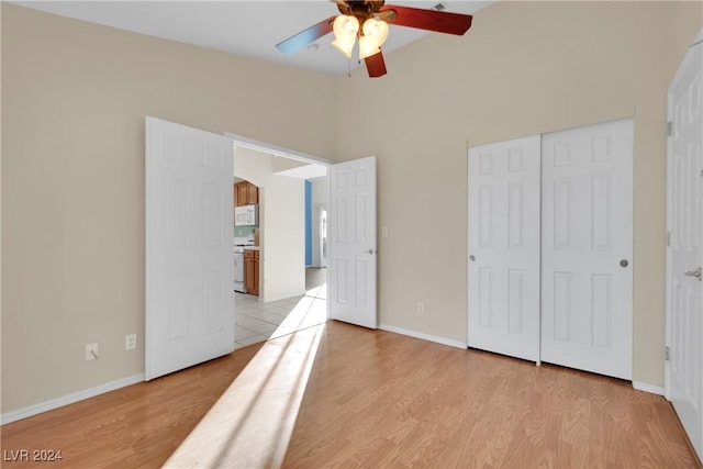 bedroom with ceiling fan, a closet, and light hardwood / wood-style flooring