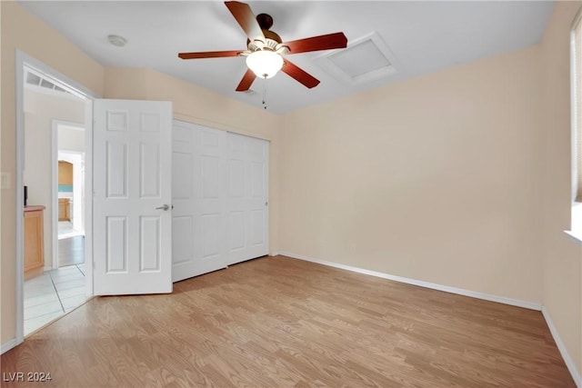 unfurnished bedroom with ceiling fan, light hardwood / wood-style floors, and a closet