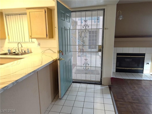 entryway featuring a tile fireplace, sink, and light tile patterned flooring