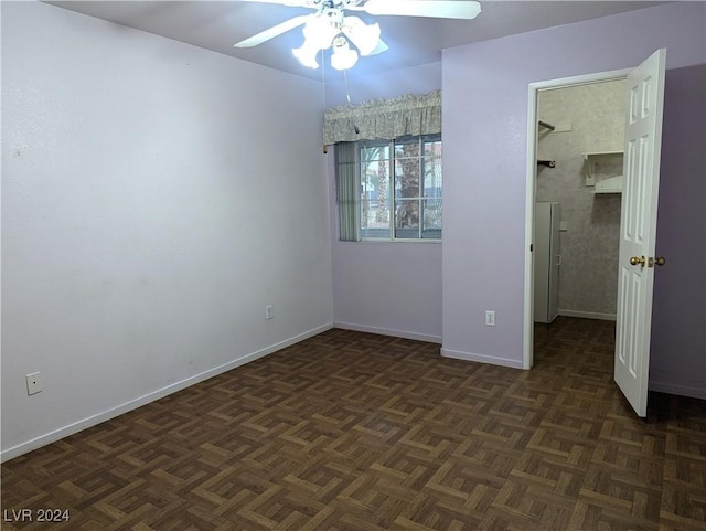 unfurnished bedroom with dark parquet flooring and ceiling fan