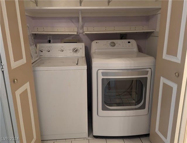 washroom with light tile patterned floors and washer and dryer