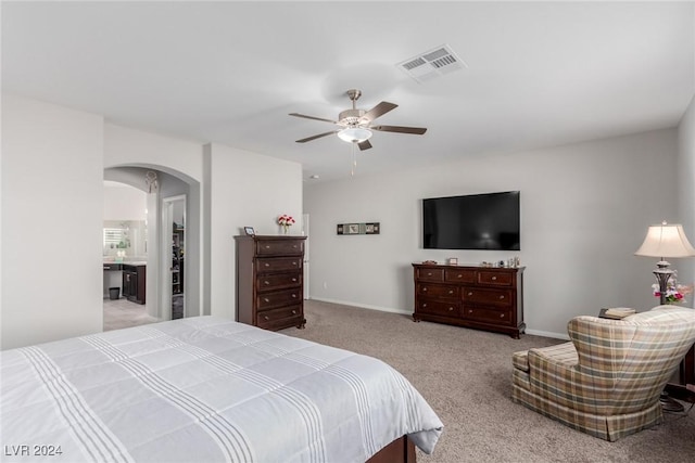 carpeted bedroom with connected bathroom and ceiling fan