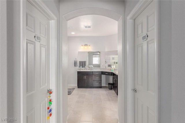 corridor with light tile patterned floors and sink