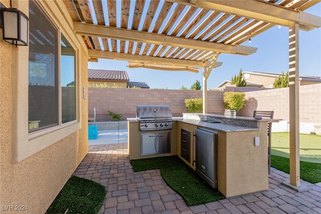 view of patio with an outdoor kitchen, a pergola, and a grill