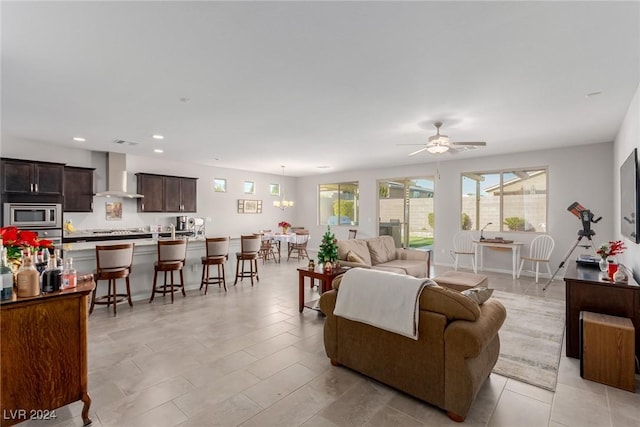 living room with ceiling fan with notable chandelier