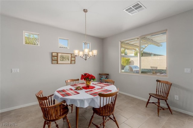 tiled dining room with a chandelier