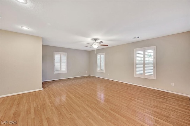 spare room featuring a wealth of natural light, ceiling fan, and light wood-type flooring