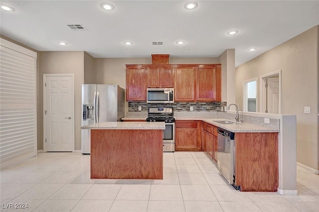 kitchen with backsplash, sink, a kitchen island, kitchen peninsula, and stainless steel appliances