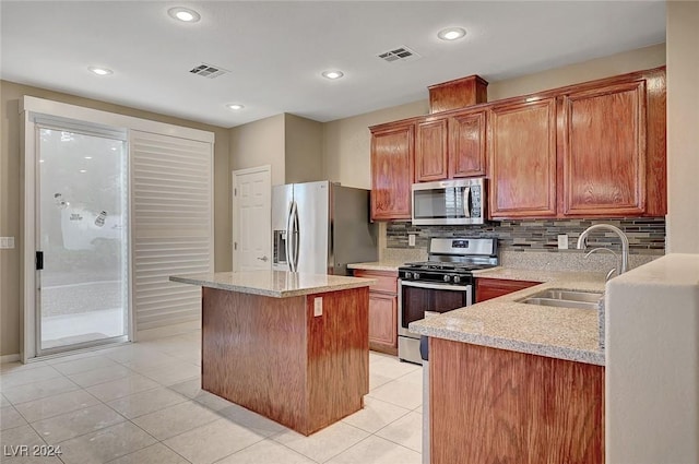 kitchen featuring a center island, sink, tasteful backsplash, light stone counters, and stainless steel appliances