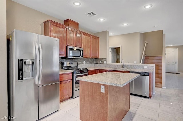 kitchen with a center island, light tile patterned floors, sink, and appliances with stainless steel finishes