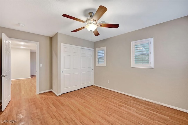 unfurnished bedroom featuring ceiling fan, light hardwood / wood-style flooring, and a closet