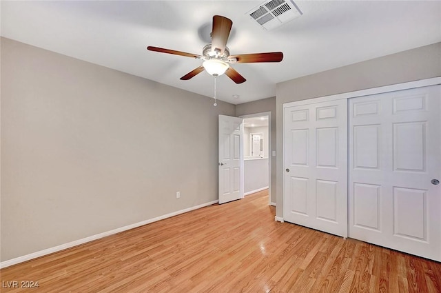 unfurnished bedroom featuring a closet, light hardwood / wood-style floors, and ceiling fan