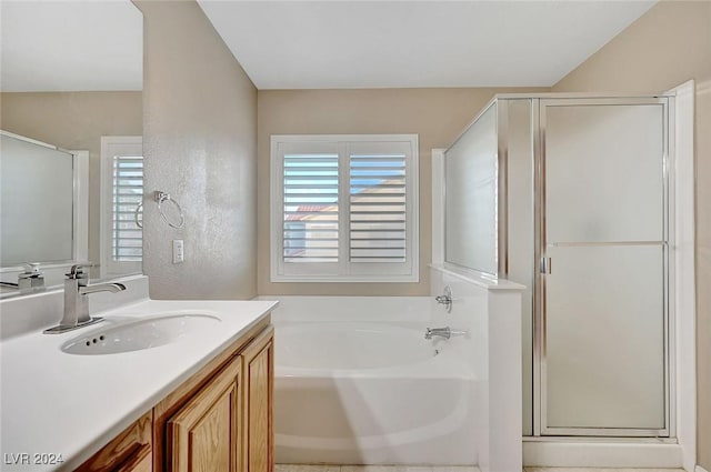 bathroom with vanity and shower with separate bathtub