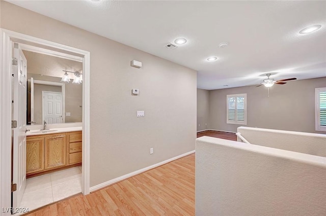 corridor with sink and light hardwood / wood-style flooring