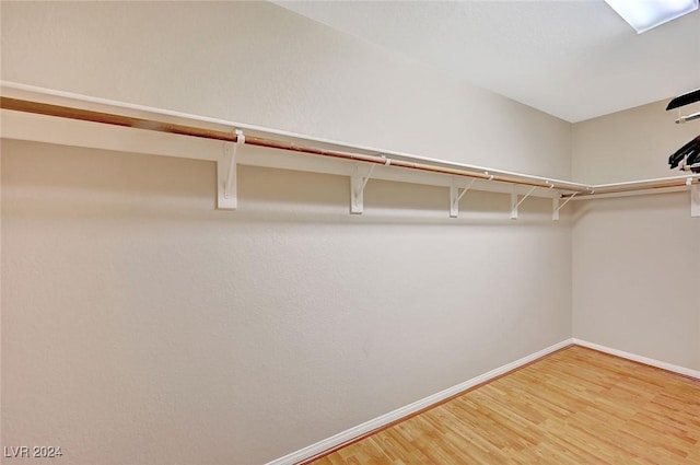 walk in closet with hardwood / wood-style floors