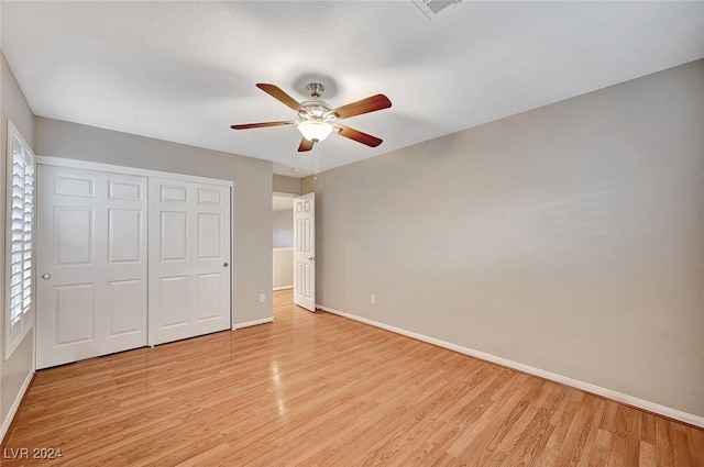 unfurnished bedroom featuring light wood-type flooring, a closet, and ceiling fan