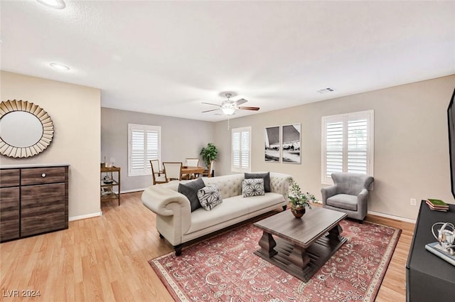 living room featuring ceiling fan, plenty of natural light, and light hardwood / wood-style floors