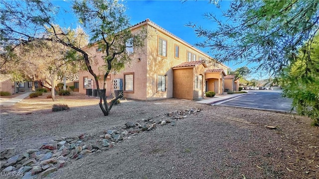 view of property exterior featuring a tiled roof and stucco siding