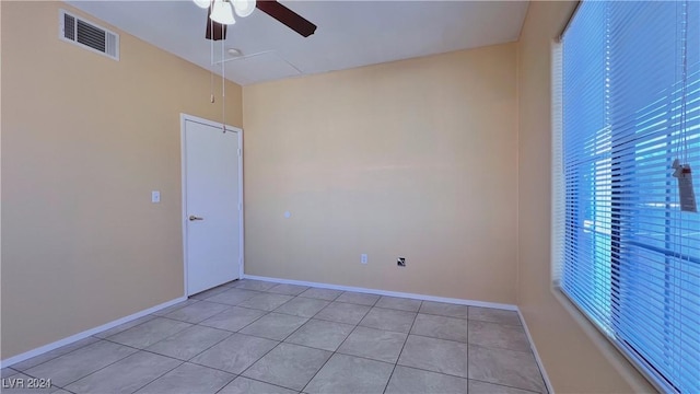 empty room featuring a ceiling fan, light tile patterned floors, and baseboards