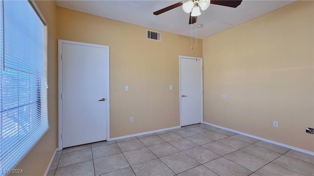 unfurnished bedroom featuring light tile patterned floors, ceiling fan, and baseboards