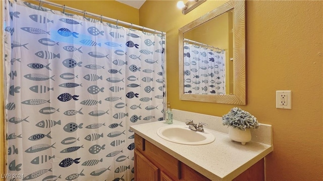 full bathroom with vanity, a shower with curtain, and a textured wall