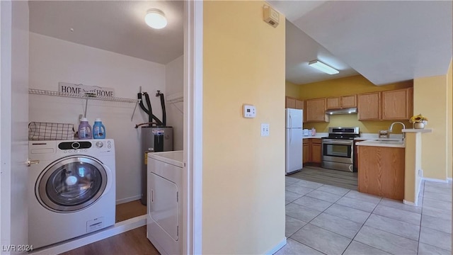 washroom featuring independent washer and dryer, baseboards, and light tile patterned flooring