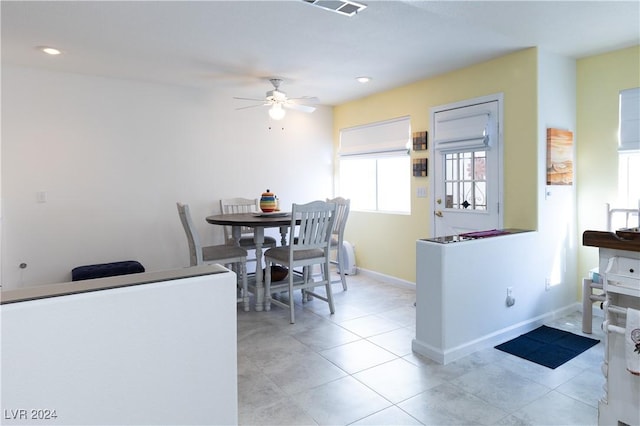 tiled dining space featuring ceiling fan