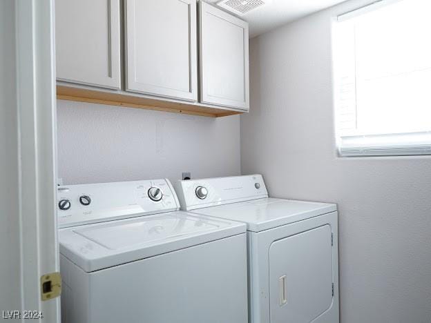 laundry room featuring cabinets and washing machine and dryer