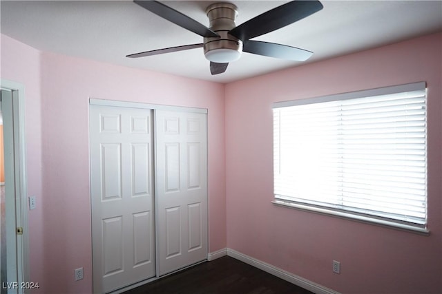 unfurnished bedroom with dark hardwood / wood-style floors, a closet, and ceiling fan