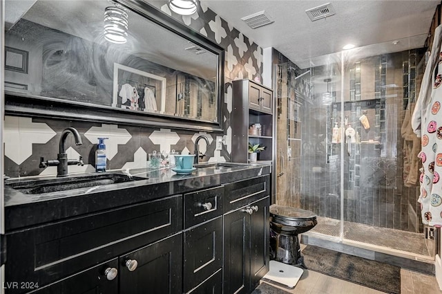 bathroom with decorative backsplash, vanity, hardwood / wood-style floors, toilet, and a shower with shower door