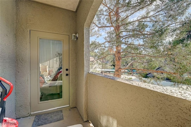 view of exterior entry featuring a balcony