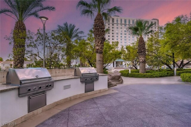 patio terrace at dusk with exterior kitchen and grilling area