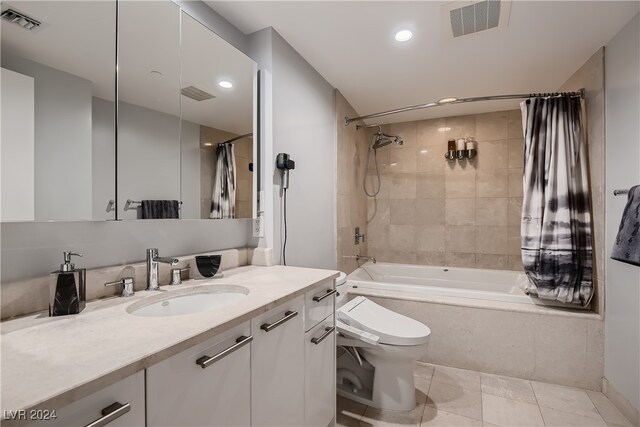 full bathroom featuring tile patterned floors, shower / bath combo with shower curtain, vanity, and toilet