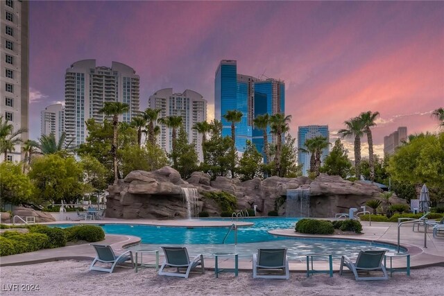 pool at dusk featuring a patio