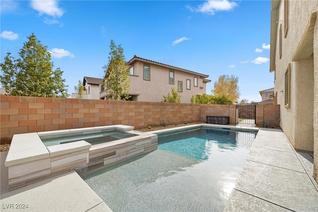 view of swimming pool with an in ground hot tub