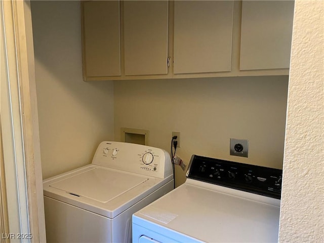 clothes washing area featuring cabinets and washer and clothes dryer