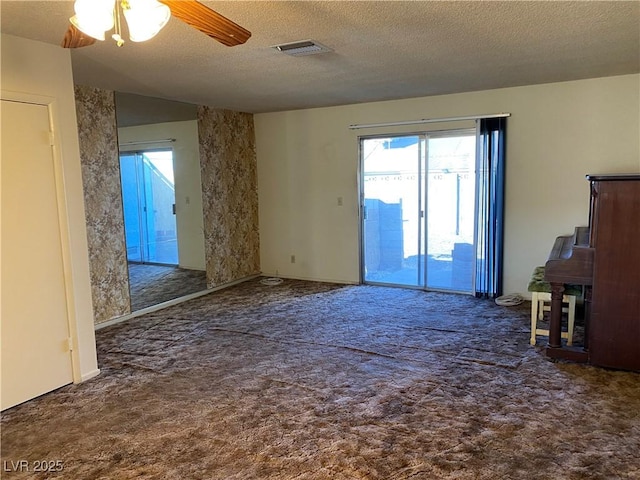 carpeted empty room featuring a textured ceiling and ceiling fan