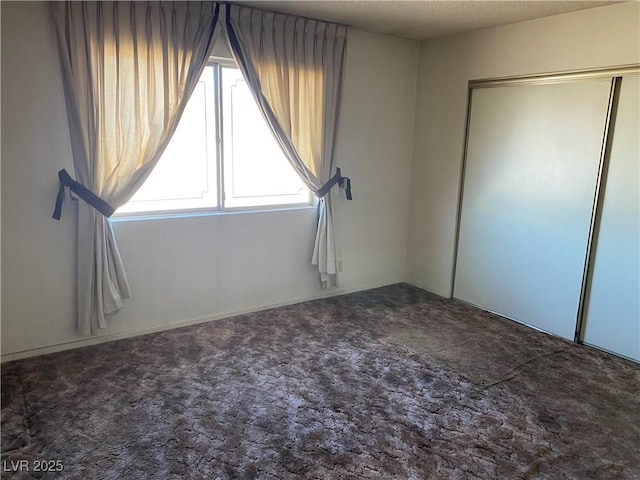 unfurnished bedroom with multiple windows, carpet floors, and a closet