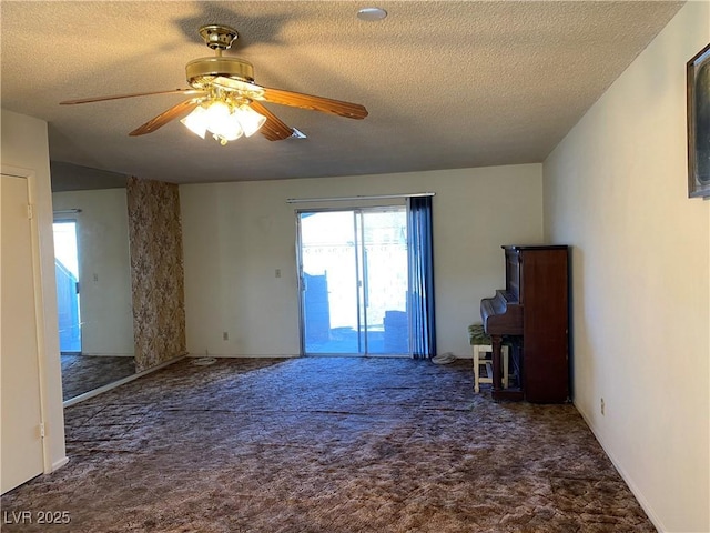 carpeted empty room with a textured ceiling and ceiling fan