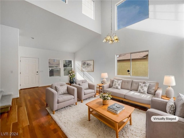 living room featuring a towering ceiling, dark hardwood / wood-style floors, and a notable chandelier