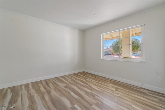 spare room with light wood-type flooring and ornamental molding