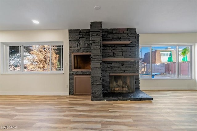 unfurnished living room featuring a fireplace and light wood-type flooring