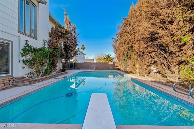 view of pool with a diving board