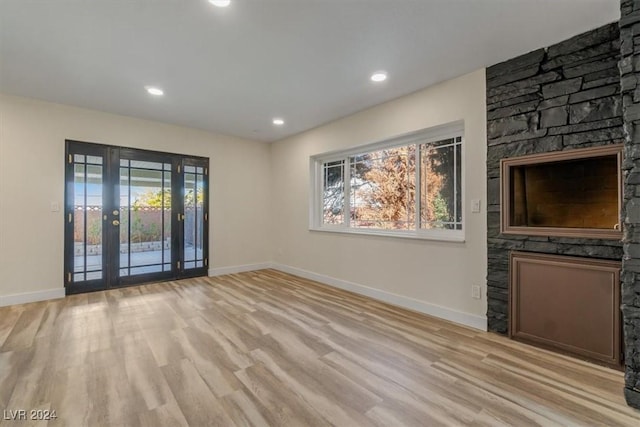 unfurnished living room with french doors and light hardwood / wood-style floors