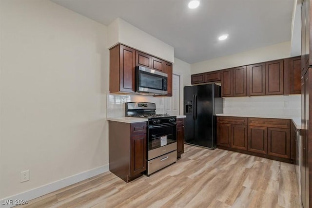 kitchen with dark brown cabinetry, stainless steel appliances, and light hardwood / wood-style floors