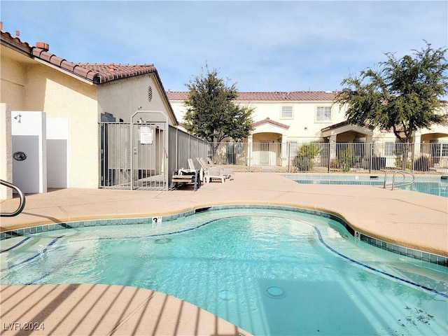 community pool featuring a patio area and fence