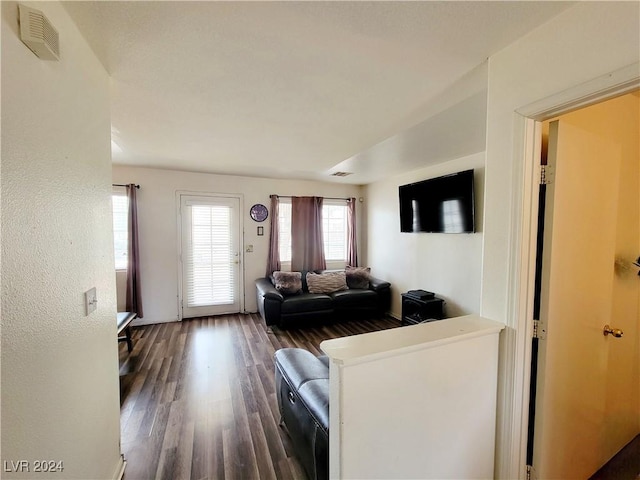 living area with visible vents and wood finished floors